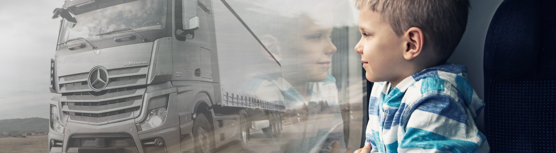 Boy sitting on the window and watching a truck passing by
