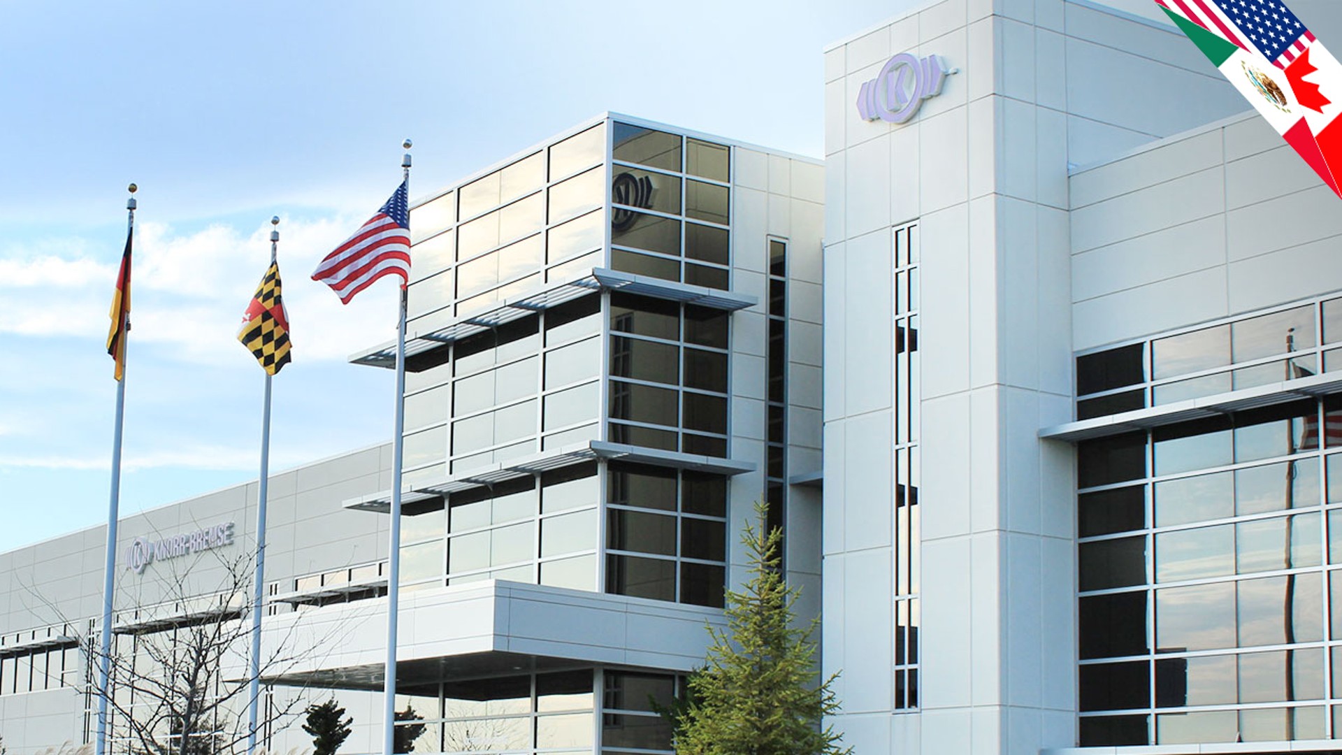 Knorr-Bremse building with flags and clear sky.